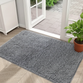 Tapis absorbant en chenille coloris gris posé devant une porte d'entrée en bois clair, décor généré autour de la photo du produit
